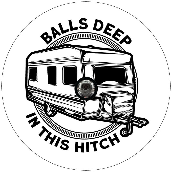 Mockup example of a white vinyl RV spare tire cover design that has a travel trailer camper graphic in the center and a funny play on words with the says "balls deep in this hitch" curved on the out top and bottom plus a hole in the middle to accommodate a vehicle that has a backup camera in their spare wheel.