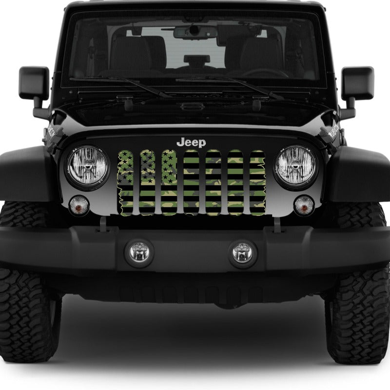 Front end of a black Jeep Wrangler displaying a tactical black and camouflage American flag Jeep grille insert. 