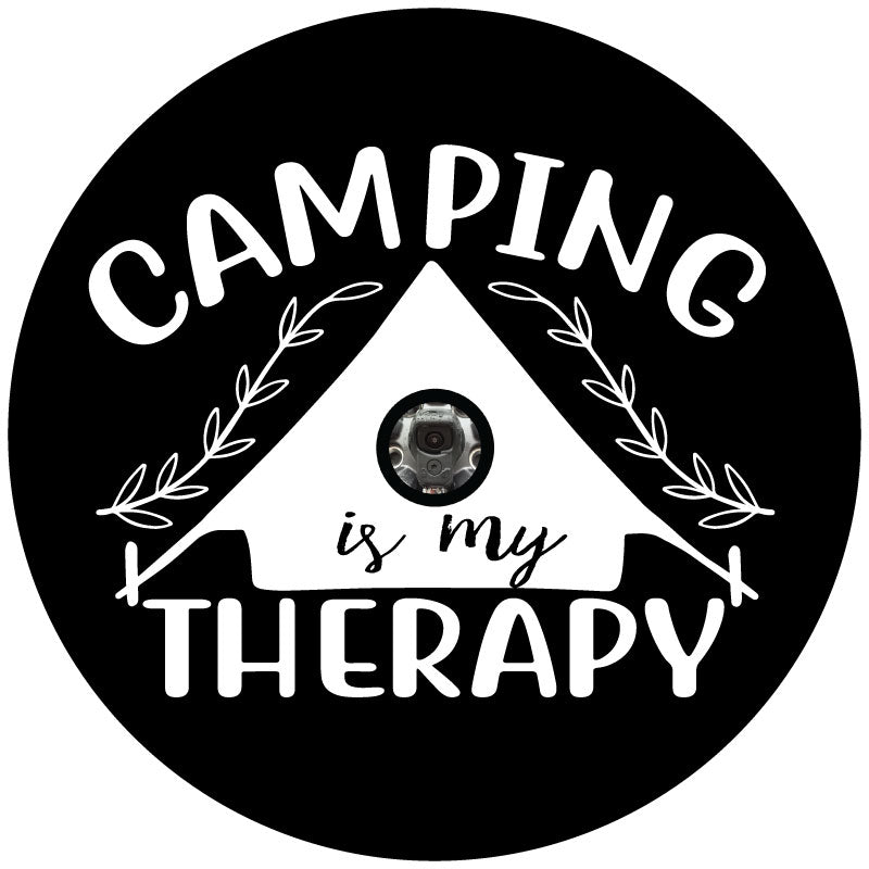 Black spare tire cover with white tent silhouette design and the saying camping is my therapy with a hole for a back up camera