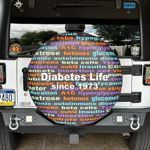 Car with a colorful diabetes-themed license plate and text on the back window.