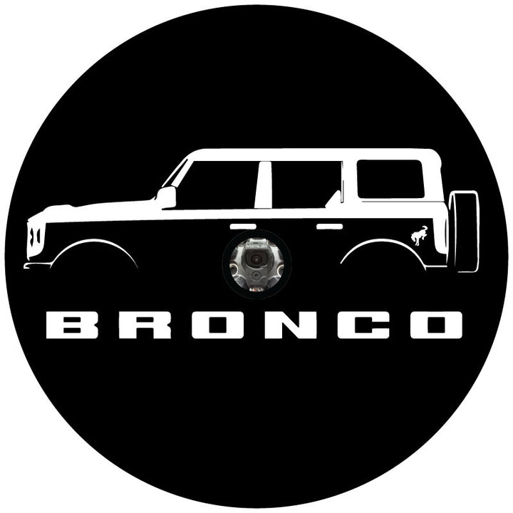 Mock up design of a custom black vinyl spare tire cover with a four door Ford Bronco silhouette, the Bronco letters below and the bucking bronco horse detail on the back fender, plus a center hole cut out for a backup camera.