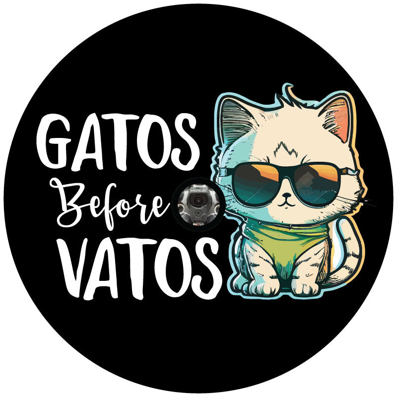 Black vinyl spare tire cover mockup with a graphic design of a cute cat wearing sunglasses and the saying, gatos before vatos with a hole to fit a spare tire that has a backup camera. 
