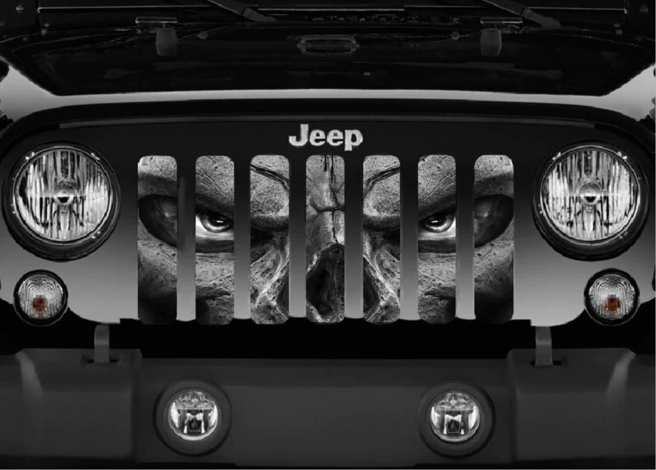 Close up view of a Jeep grille insert design of a skeleton in grayscale with gray eyes fiercely watching you. 