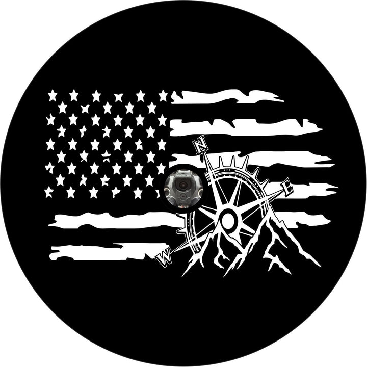 Black vinyl spare tire cover design with a white rustic American flag and a mountain and compass in the forefront with a space or hole for spare wheels that have a backup camera