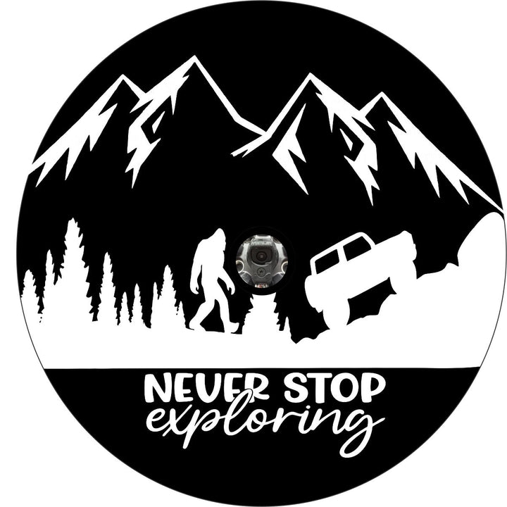 Black vinyl spare tire cover graphic design with white mountains, trees, and sasquatch walking to a Ford Bronco with the words never stop exploring underneath. Includes a whole for a back up camera.