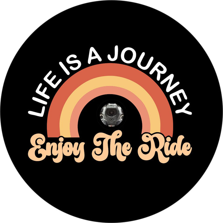 A mockup design idea of a spare tire cover. Cute and creative spare tire cover design is a fun addition to any exterior wheel. With the phrase, "life is a journey, enjoy the ride" and a fun orange, peach, yellow shaded rainbow design. Spare tire cover can accommodate a backup camera