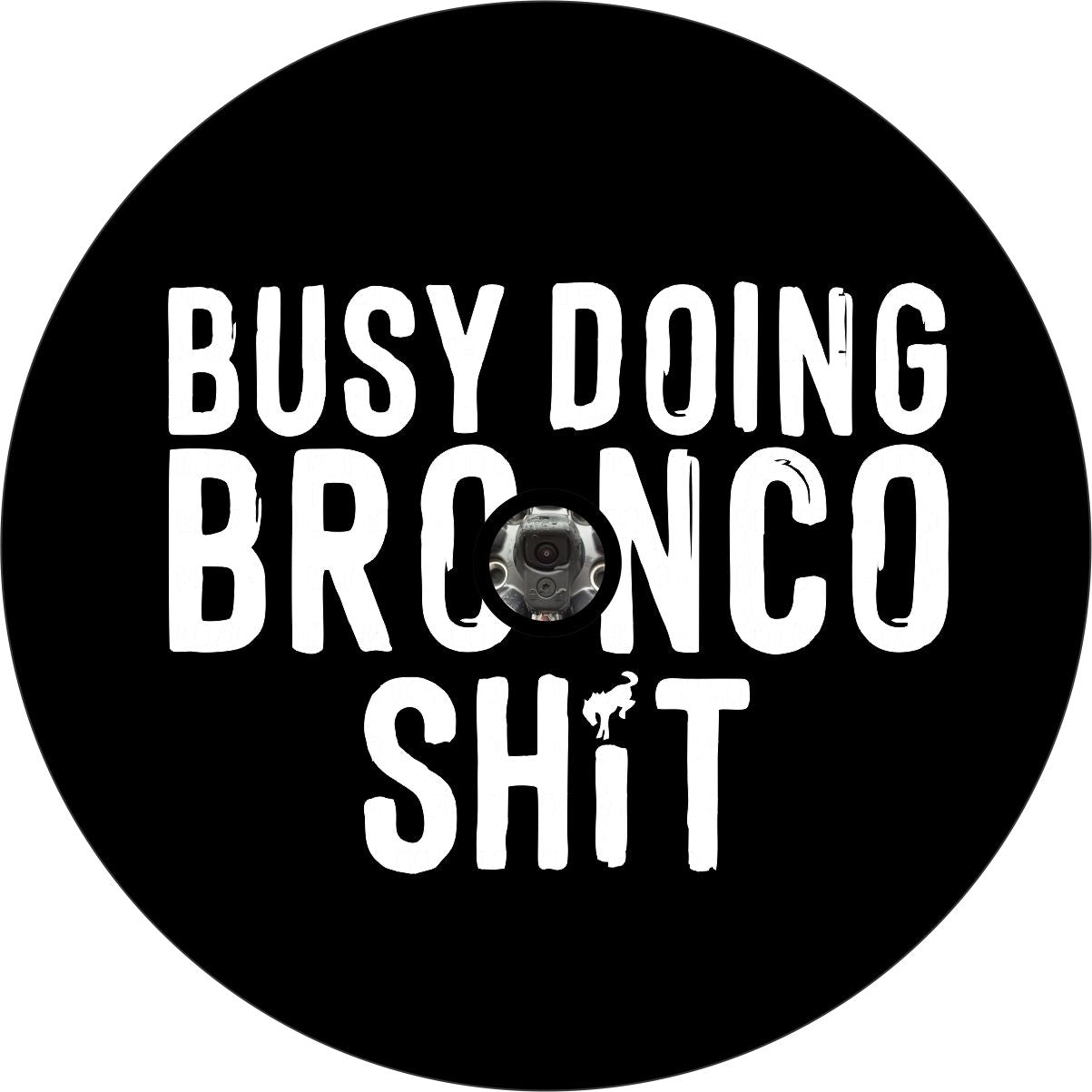 Black vinyl spare tire cover that boldy says "busy doing Bronco shit" and the dot in the I is a Bronco horse icon plus a place for a back up camera.