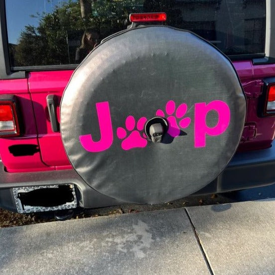 Pink Jeep and a custom spare tire cover with the word Jeep and two paw prints in place of the E's in matching pink color. 