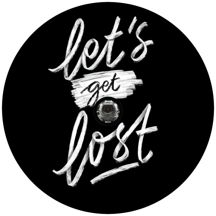 A mockup design of a black vinyl spare tire cover handwritten that says "Let's Get Lost" in cursive font in white with a hole to accommodate a spare tire that has a backup camera in the center.