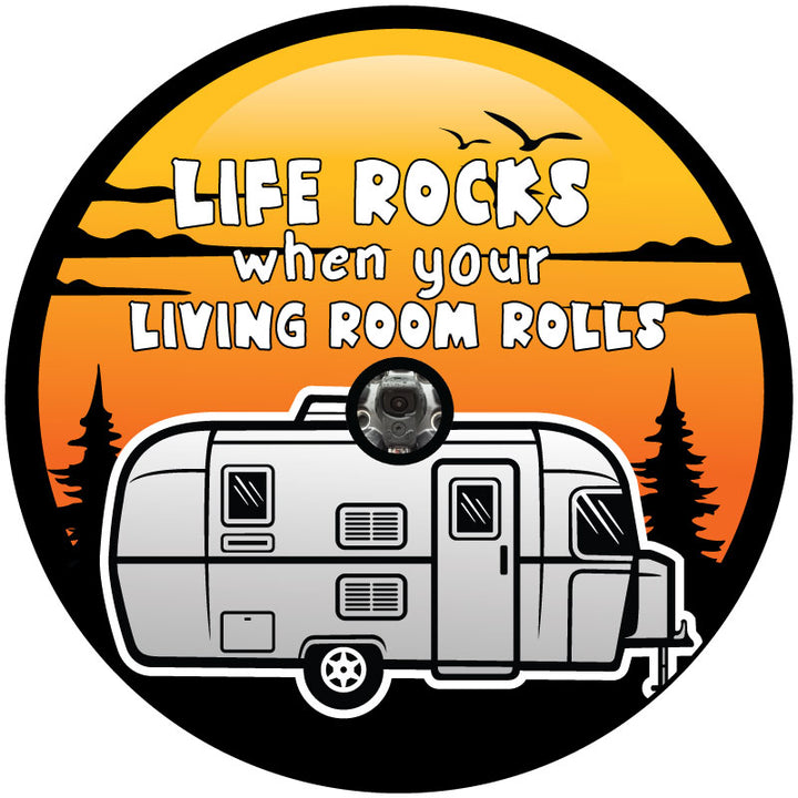 Graphic of a spare tire cover for RV, camper, trailers, and more. Design says life rocks when your living room rolls and has an orange and yellow sunset background with trees and a RV travel trailer graphic plus a place in the center to accommodate spare wheels that have backup cameras