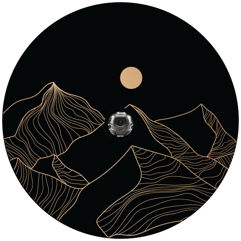 Mock up design of a black vinyl spare tire cover with a linear hand drawn mountain landscape and the sun or full moon hung in the sky with a center hole for a backup camera