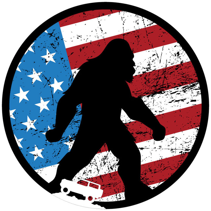 Mockup spare tire cover design for a soft black vinyl spare wheel, design is a rustic American flag red, white, and blue background with a black silhouette of Sasquatch bigfoot and a small white Ford Bronco icon on the bottom