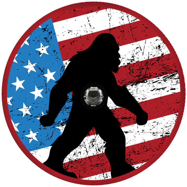 Spare tire cover design displaying a tactical American flag background and a silhouette of sasquatch walking. Center hole in design to show accommodation for a backup camera.