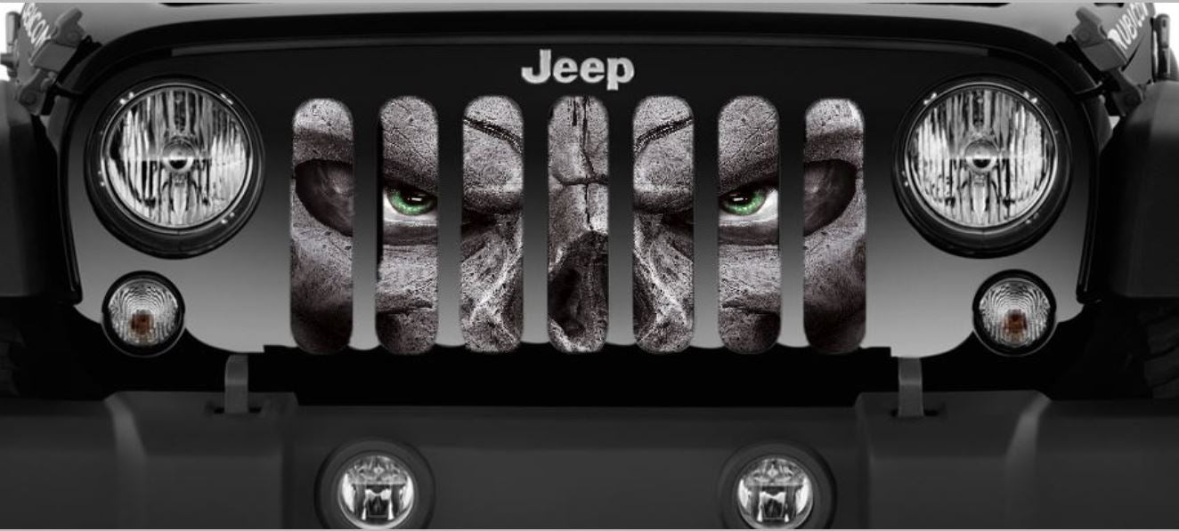 Close up view of a Jeep grille insert design of a evil skeleton face with green eyes