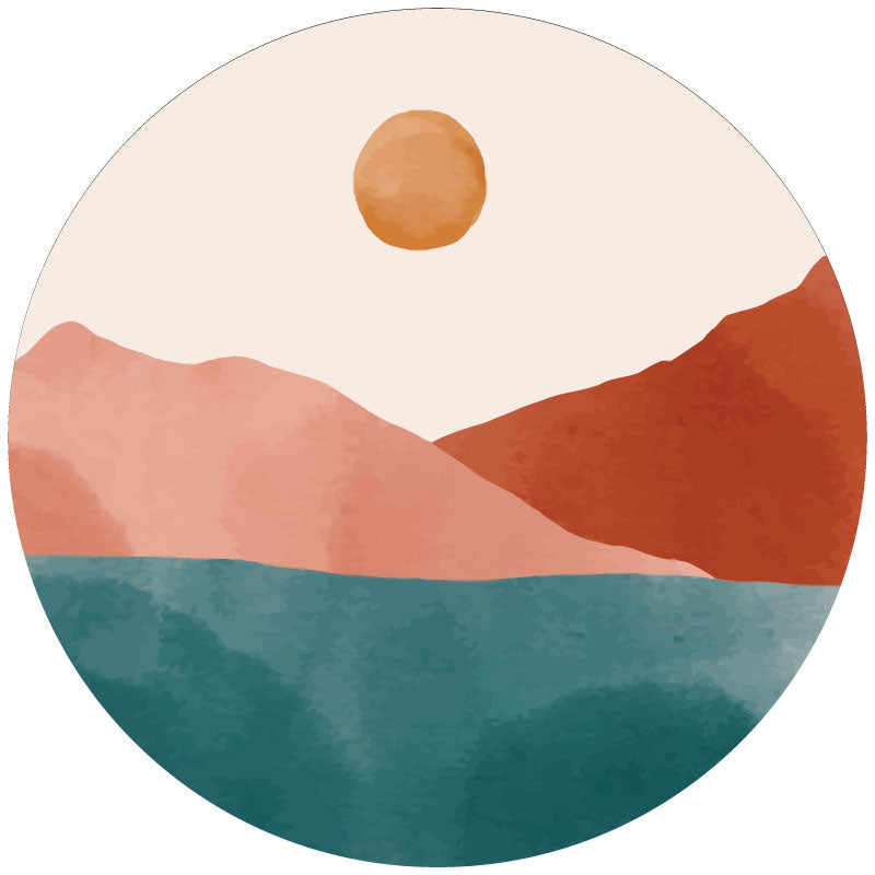 Mockup example of a spare tire cover design that has jewel tone mountain landscape to look like it was painted with watercolors. Teal, brick, and light brick coloring with a sun in the sky.