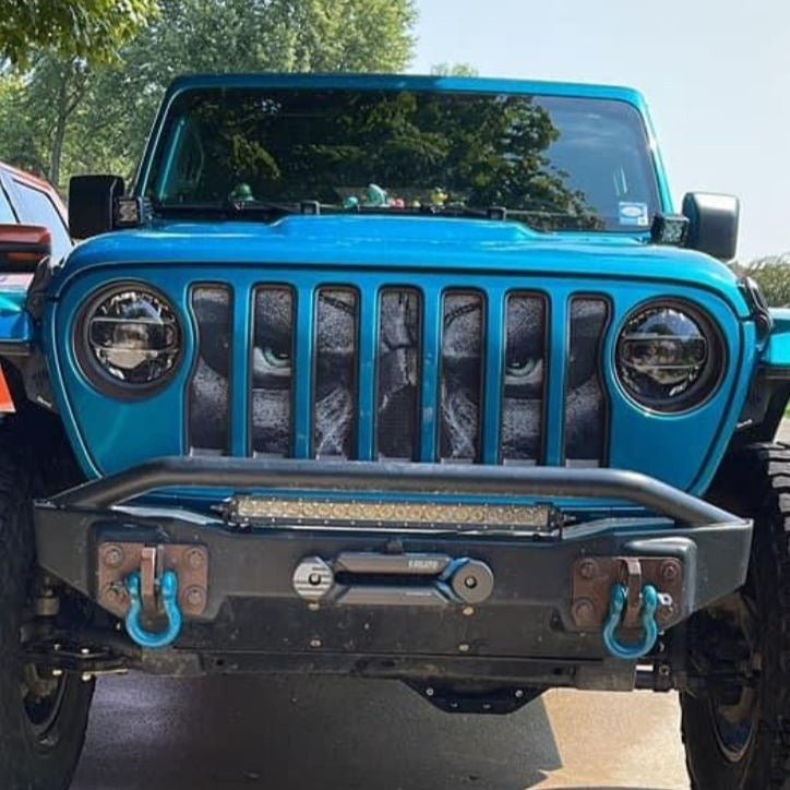 Teal Jeep Wrangler showing a Jeep grille insert design of a spooky skeleton with teal eyes. 