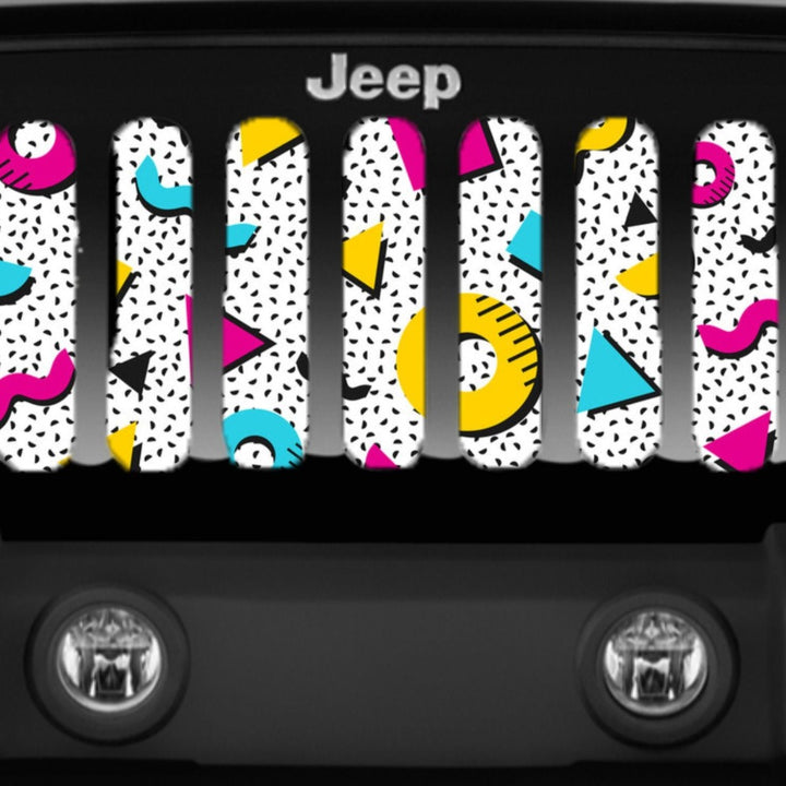 Close up view of a Jeep grille insert inside a black Jeep Wrangler of a 90's retro Saved by the Bell pattern with shapes and bright colors of pink, yellow, and blue