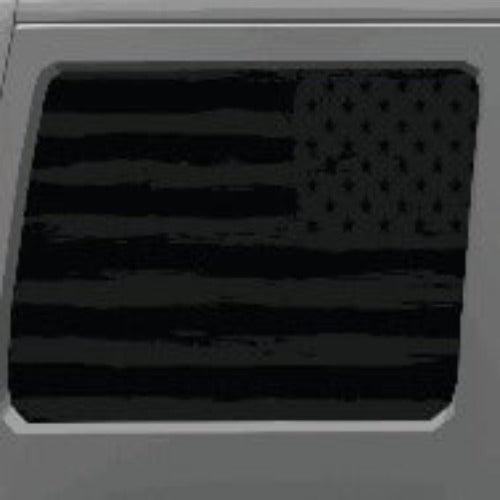 Close up look of the rustic dark gray American flag decal window cling on a white Jeep Wrangler's back window.