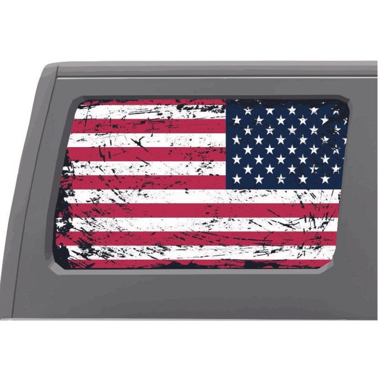 Close up look of a rustic American flag designed window decal sticker on a white Jeep Wrangler's back window.