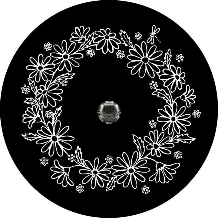 Mock up spare tire cover design for newers spare wheels that have backup cameras in the center, black vinyl spare tire cover with a white wreath of daisies and dragonfly