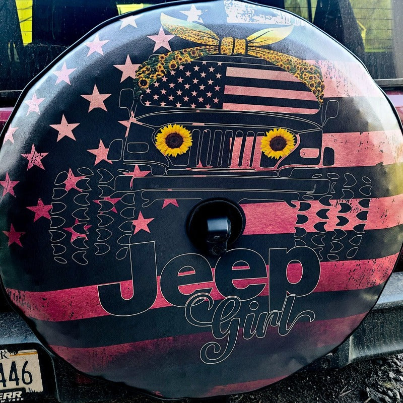 Custom spare tire cover for Jeep Wrangler. Jeep girl written across a Tuscadero pink ombre color. American flag in the back and a Jeep Wrangler silhouette with large tires, sunflower headlights, and a sunflower head band on the Jeep Wrangler.