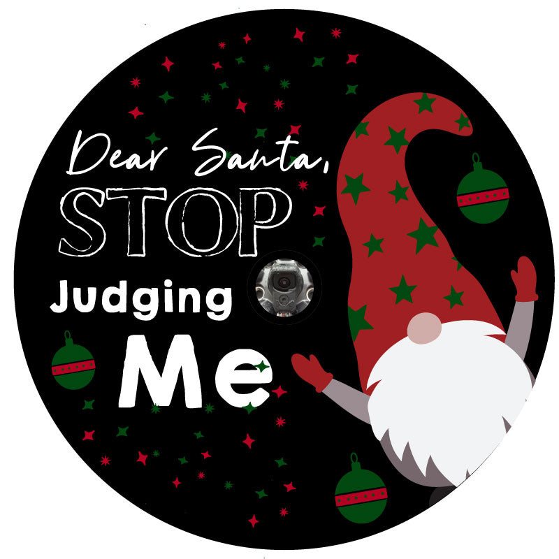 Funny spare tire cover saying Dear Santa, Stop Judging Me with a Christmas Scandinavian gnome popping out. Tire cover is designed to fit spare tires outfitted for a backup camera