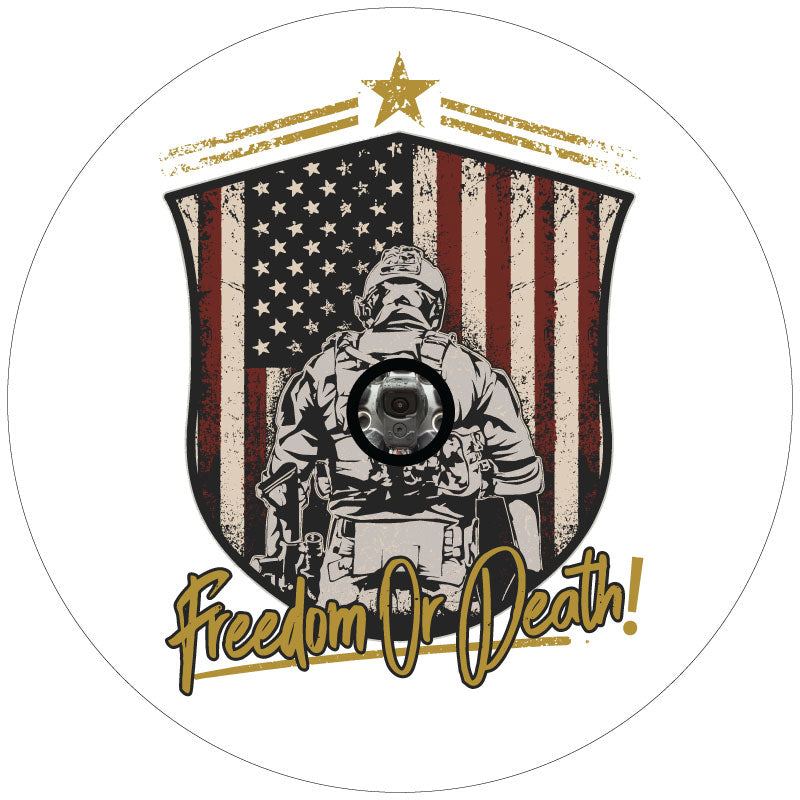 American flag insignia with a silhouette of the back of a soldier in front of the flag with the saying Freedom or Death in script on a white vinyl spare tire cover for Jeep, Bronco, RV, Camper, Van, and more designed with a back up camera