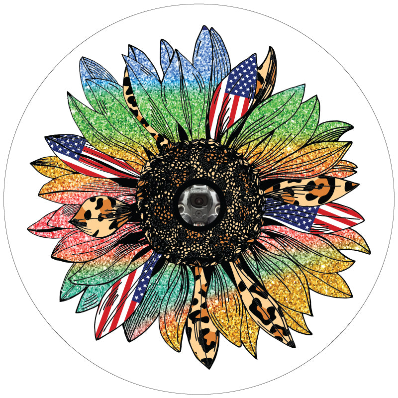 A sunflower spare tire cover with rainbow sparkle petals, American flag petals, and cheetah print or leopard print animal print petals. This design is displayed to show the sunflower on a white vinyl spare tire cover with a JL back up camera accommodation.