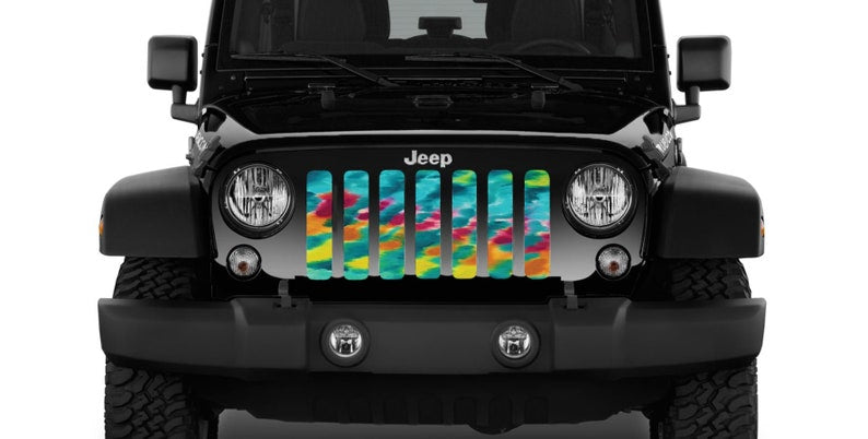 Close up view of a Turquoise Tie Dye Design Grille Insert for Jeep on a black Jeep Wrangler.