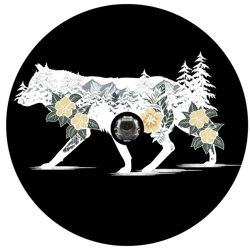 white silhouette of a wolf unique spare tire cover design with the wild wilderness mountains, trees and flowers double exposed inside the wolf on black vinyl with a back up camera