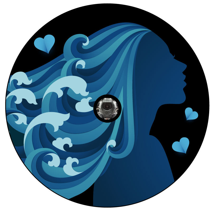 Unique spare tire cover design of a silhouette of a woman in the colors teal and blue with long flowing beautiful hair that looks like the ocean and waves crashing with a back up camera