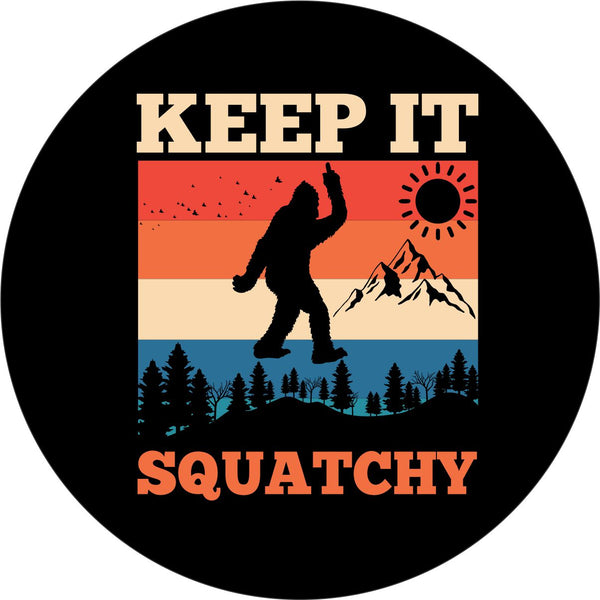 Black vinyl spare tire cover that says Keep It Squatchy, with a bigfoot silhouette giving the middle finger and a colorful mountain backdrop