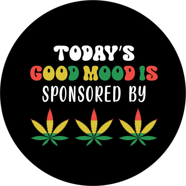 Spare tire cover with the saying "today's mood is sponsored by" and the shape of cannabis leaves colored with rasta red, yellow, green colors.